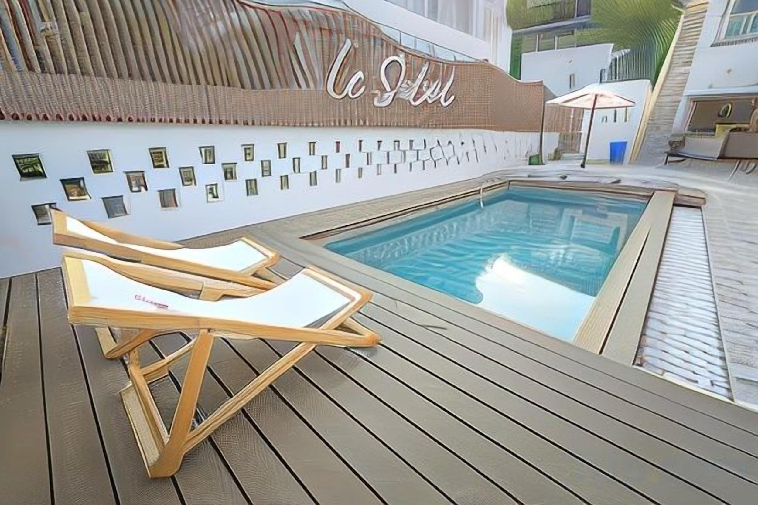 A poolside area with lounge chairs, a sign reading 'La Selva', and a small pool.