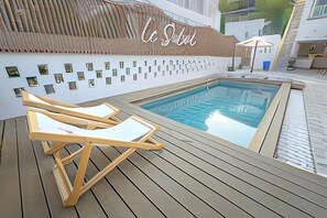 A poolside area with lounge chairs, a sign reading 'La Selva', and a small pool.