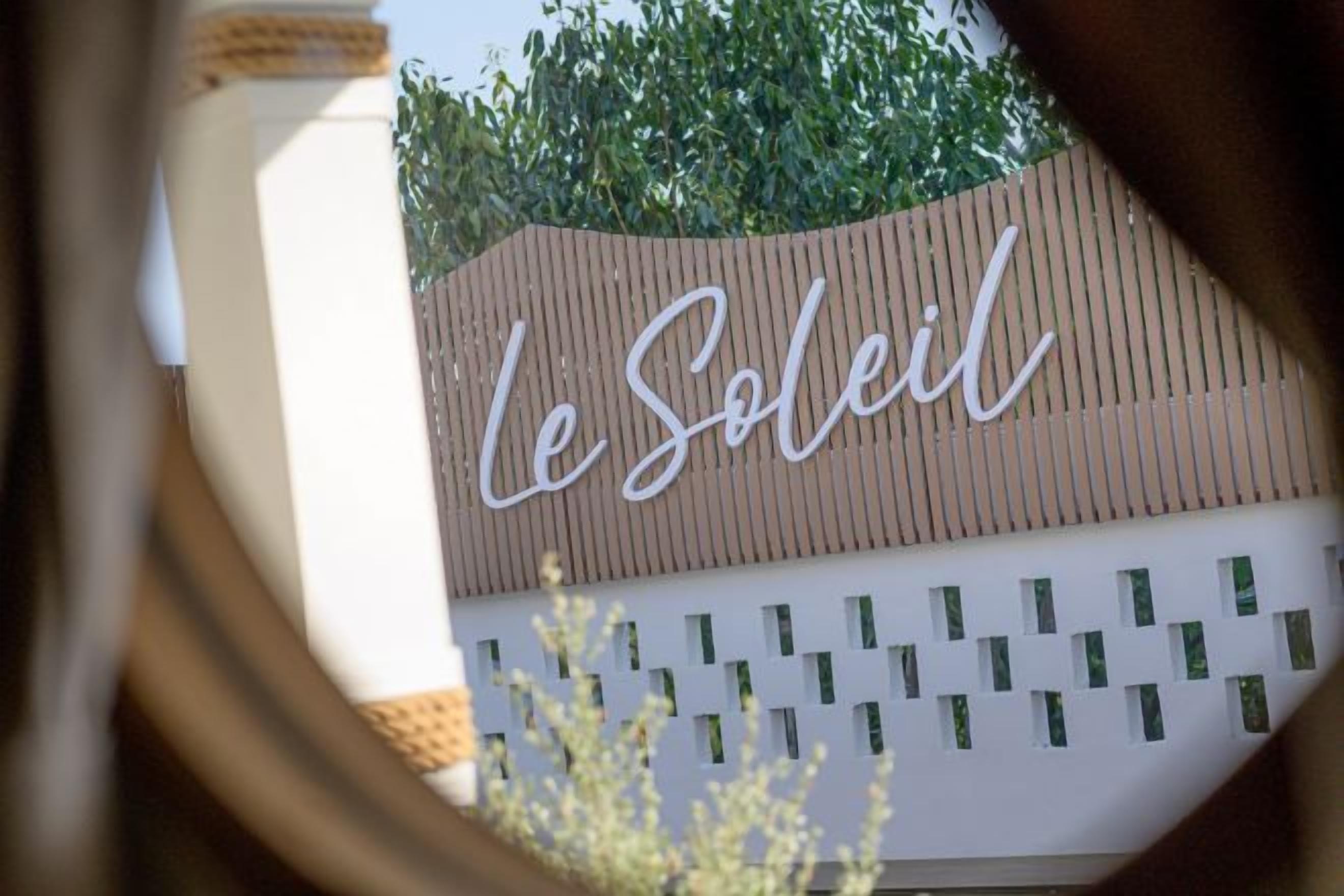 A sign with the text "Le Soleil" on a building facade.