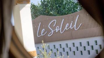 A sign with the text "Le Soleil" on a building facade.
