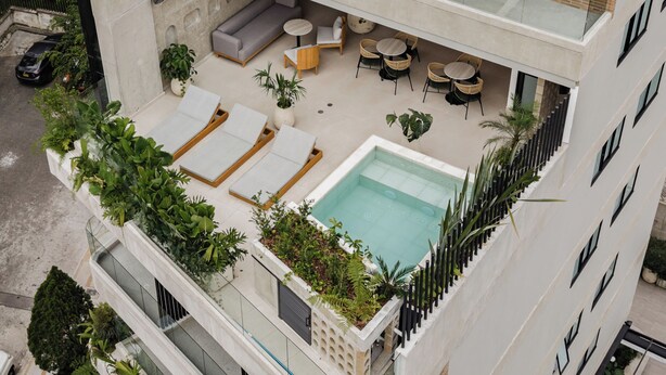 A rooftop terrace with a pool, lounge chairs, and outdoor seating. - Lomm By Somos The Group (Medellín)