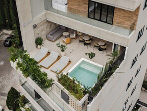 A rooftop terrace with a pool, lounge chairs, and outdoor seating. - Lomm By Somos The Group (Medellín)