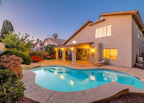 A house with a swimming pool, outdoor seating, and a patio area.