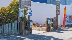 A coastal access sign with multiple informational posters, a wooden fence, and a no smoking sign. - Beach Bum Retreat (Cayucos)