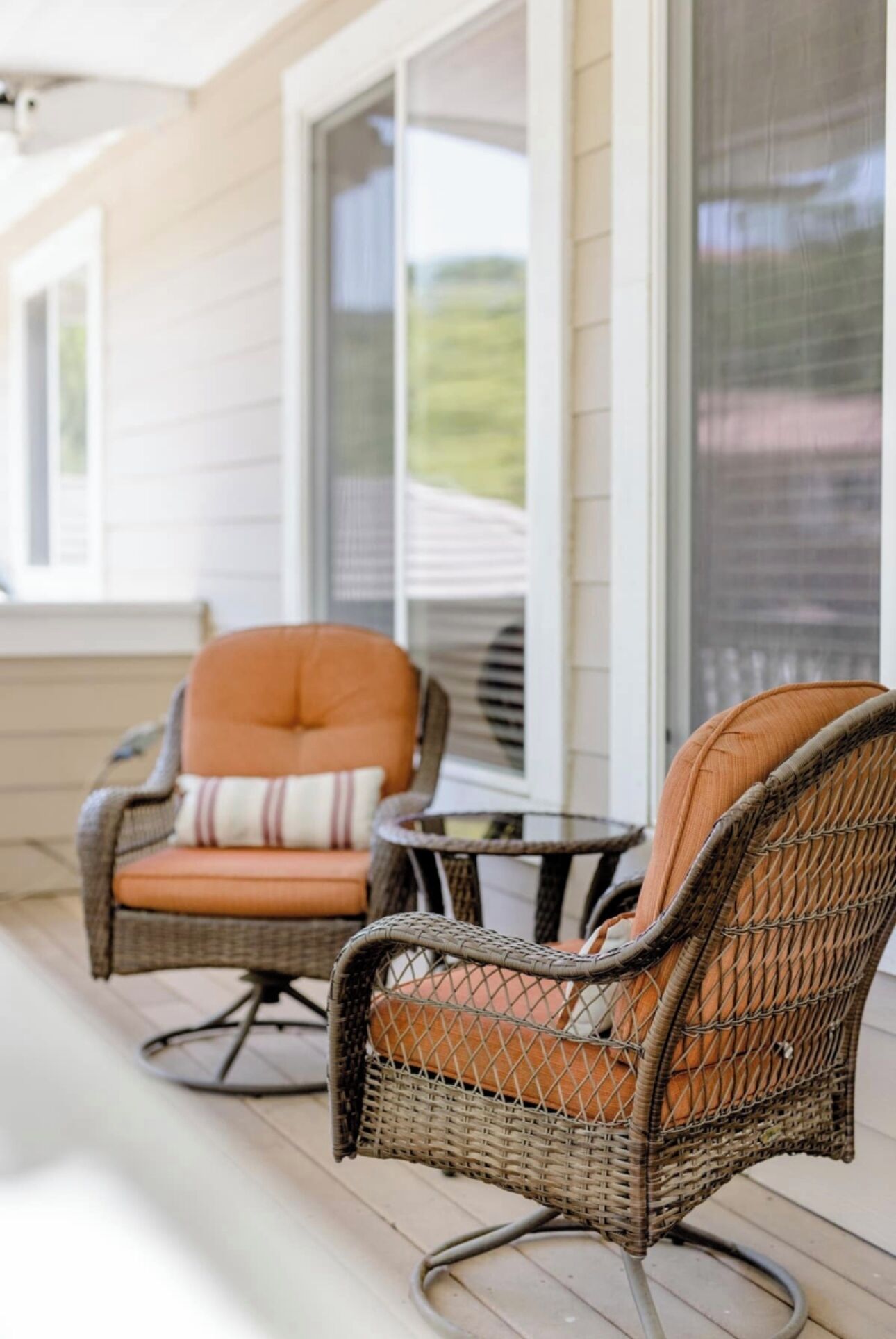 A porch with wicker chairs and a small table.