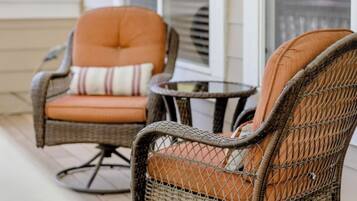 A porch with wicker chairs and a small table.