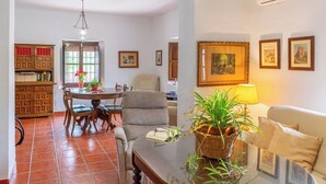A living room with a sofa, a table with a lamp, and a bookshelf. - La Zaranda de Pinillos Antequera by Ruralidays (Málaga)