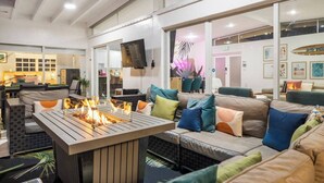 Un espace de détente moderne doté d’un foyer, de sièges confortables et d’un téléviseur.