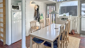 A compact kitchen with a built-in microwave, a dining table with chairs, and a small seating area with a bench. - Nice home in Aabenraa with swimming pool (Aabenraa)
