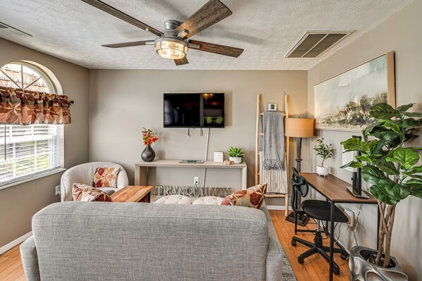 A modern living room with a ceiling fan, a TV, a desk with a chair, and a large plant. - 5 Mi to Dtwn Somerset! Country Retreat w/ Gazebo (Somerset)