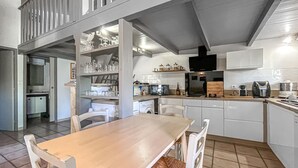 A kitchen with a dining table, chairs, and a microwave. - Amazing home in Aramon with swimming pool (Aramon)