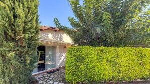 A house with a stone patio, a covered porch, and a well-maintained hedge. - Amazing home in Aramon with swimming pool (Aramon)