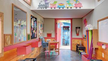 Ein Kinderzimmer mit einer Wanddekoration zum Thema Eisenbahn, Holzwänden und verschiedenen Spielmöbeln.