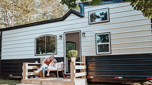 A mobile home with a porch, a small garden, and a window. - Charming Tiny Home in Pace Near Downtown and Pensacola Beach, 2 min from Walmart (Pace)