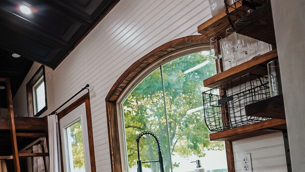A kitchen with white cabinets, a wooden countertop, and a window with a view of greenery. - Charming Tiny Home in Pace Near Downtown and Pensacola Beach, 2 min from Walmart (Pace)