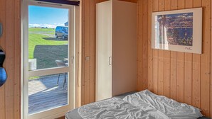 A bedroom with a bed, a wardrobe, and a door leading to a deck. - Amazing apartment in Faaborg with sauna (Faaborg)