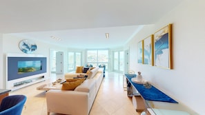 A spacious living room with a television, sofa, and coffee table.