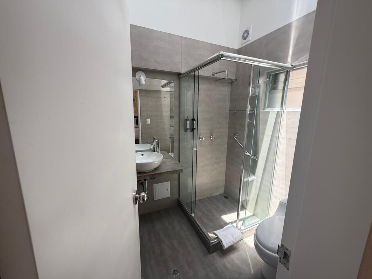 Une salle de bain moderne avec une douche à parois de verre, un lavabo et des toilettes.