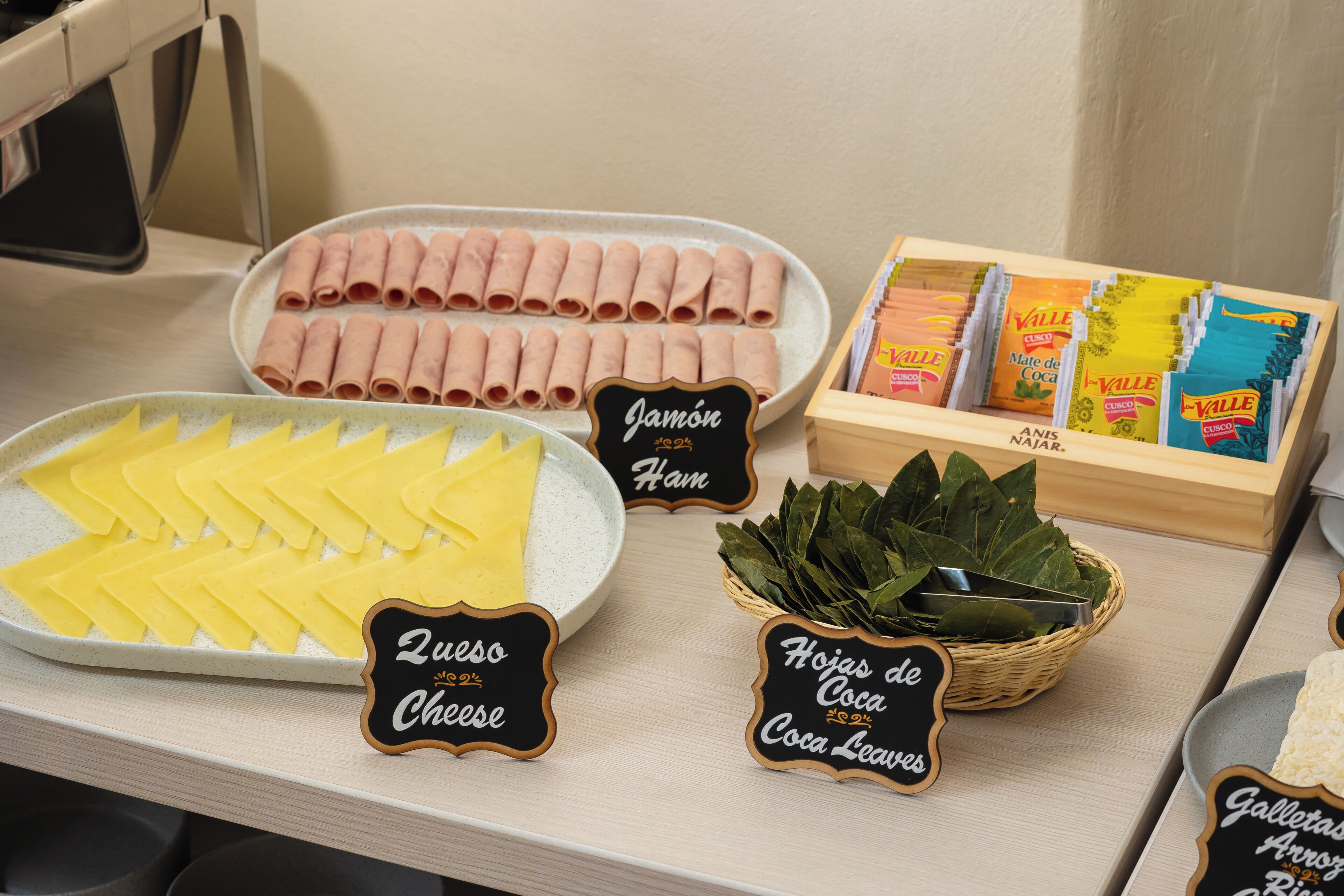 Een buffet met diverse soorten eten, zoals ham, kaas en chocoladekoekjes.