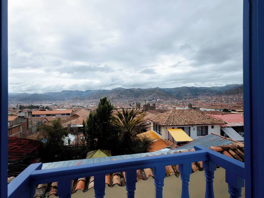 Un balcón con vistas a un paisaje urbano y montañas.