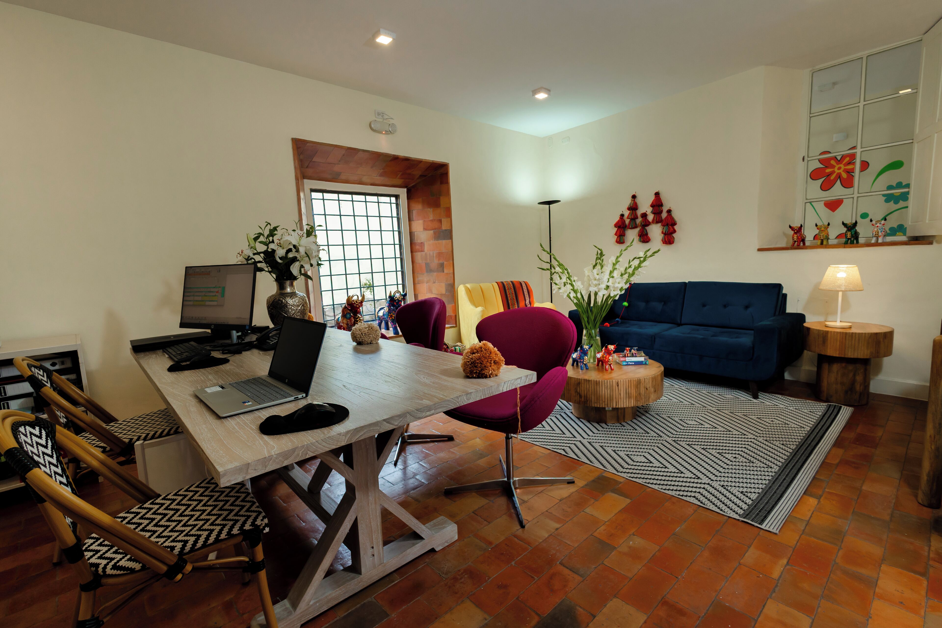 Un salon moderne avec un coin repas, comprenant une table en bois, des chaises, un canapé et un divan bleu.