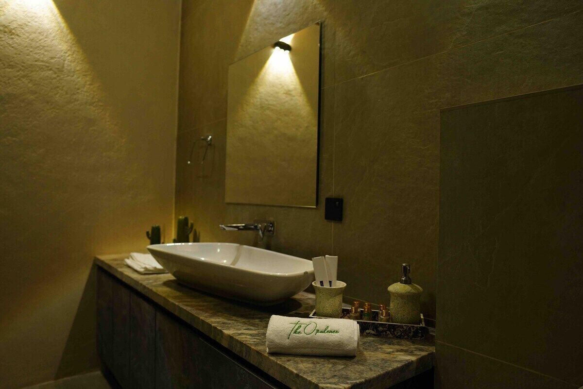 A bathroom with a large vessel sink, a mirror, and a towel with "The Ordnance" written on it.