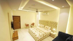 A bedroom with a bed, bedside table, nightstand, and a ceiling fan. - 3 Bhk Penthouse|Jacuzzi | Pool Table|The Opulence (panchkula)
