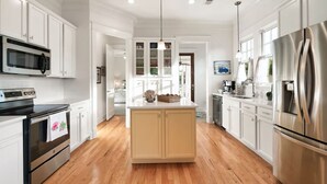 A modern kitchen with white cabinetry, stainless steel appliances, and a wooden floor. - Luxury 2BR/2BA in Thompson’s Station (Thompson`s Station)
