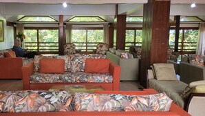 A spacious living area with a sofa set, a coffee table, and a side table with a vase. - Guesthouse on Rua Torta, 2 bedrooms, swimming pool, fireplace, free parking. (Gramado)