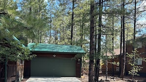 A single-story building with a green roof, a garage, and a driveway. - Charming 3-bedroom mountain house in the pines @ Pinetop Country Club (Pinetop Country Club)