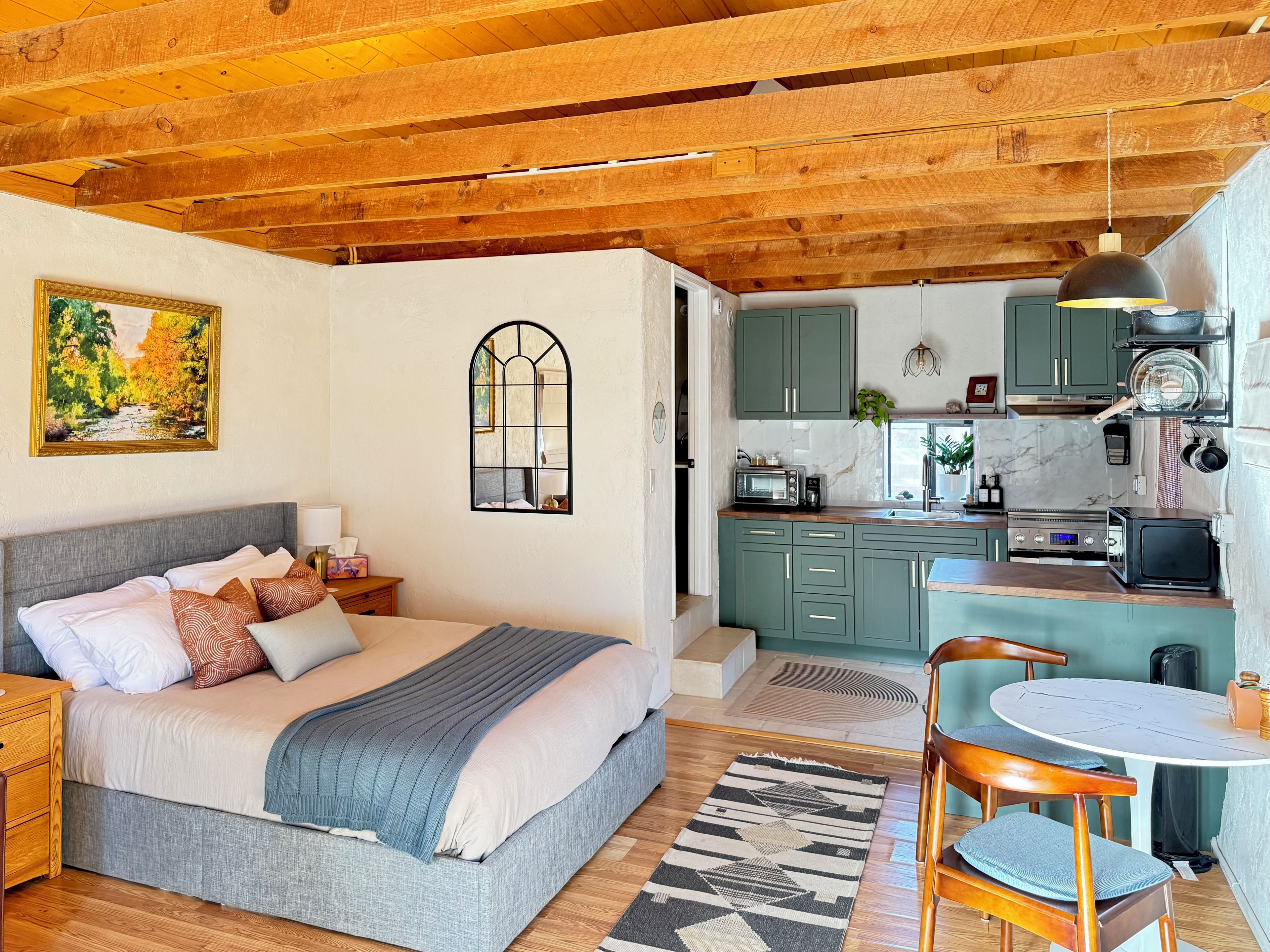 Un dormitorio con cama, mesita de noche y vistas a la cocina.