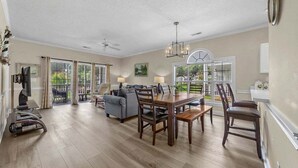 A spacious living area with a dining table, chairs, a sofa, and a ceiling fan. - Quiet 1st-Floor w/ Pool Views Near Myrtlewood Golf | MW 4665-104 (Myrtle Beach)