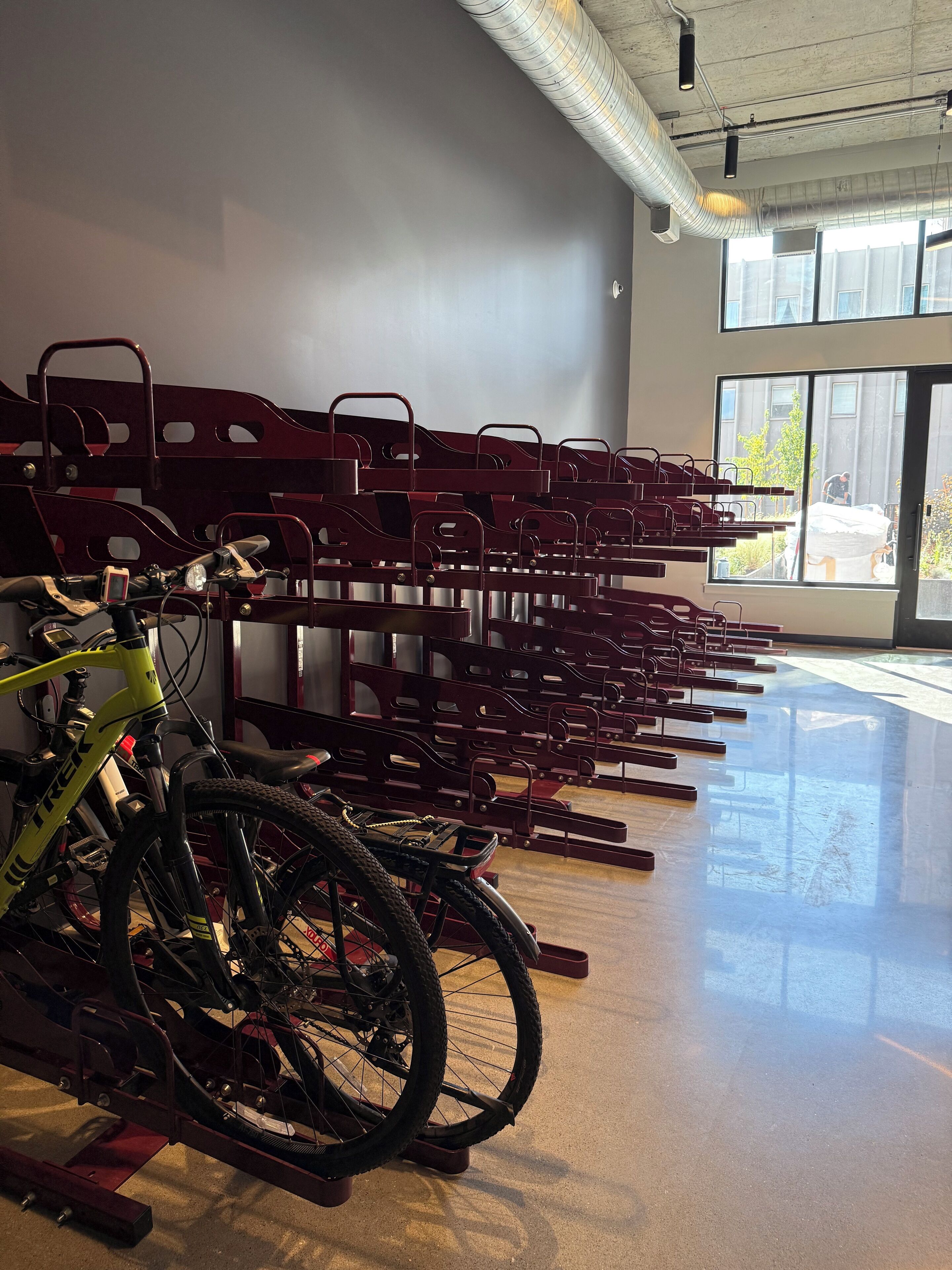 Una estación de alquiler de bicicletas con varias bicicletas, y una bicicleta amarilla al frente.