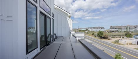 A balcony with a view of a street and houses.