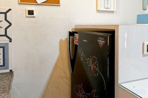 A kitchen with a refrigerator, a microwave, and a wooden cabinet. - BEST View 2BR Apt Pluit w/ Pool WiFi & Netflix (North Jakarta)