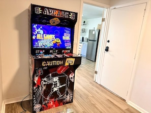 Una máquina de videojuegos retro con un letrero de precaución y un gráfico de esqueleto.