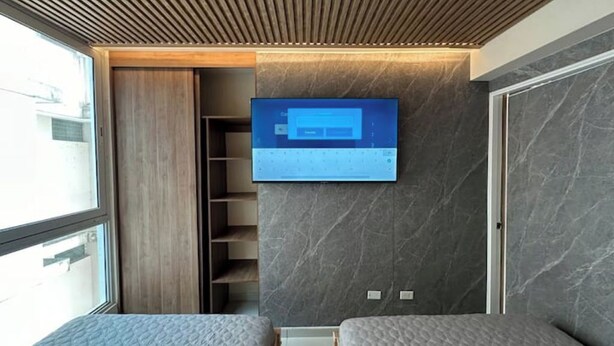 A modern hotel room with a built-in TV on the wall, a wooden ceiling, and a large window. - 5B - Masterpiece! (Panamá)