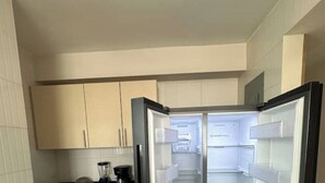 A modern kitchen with white cabinets, a built-in refrigerator, and a coffee maker. - 5B - Masterpiece! (Panamá)