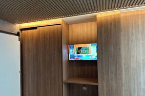 A modern room with wooden paneling and a flat-screen TV mounted on the wall.