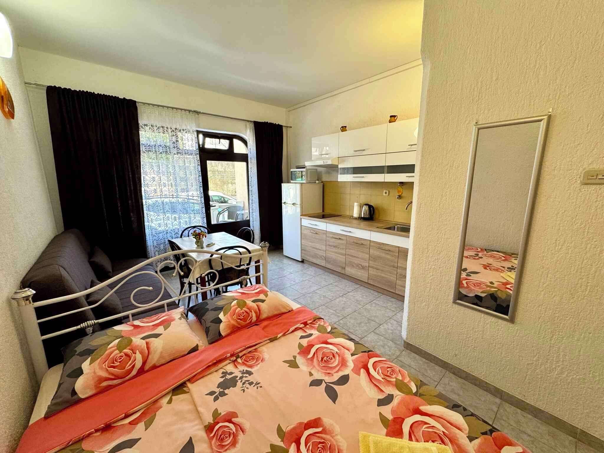Un dormitorio con una cama, una mesita y vista a la cocina.