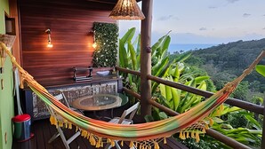 A hammock on a wooden deck with a view of a lush landscape. - Villas do Pratagy (Maceió)