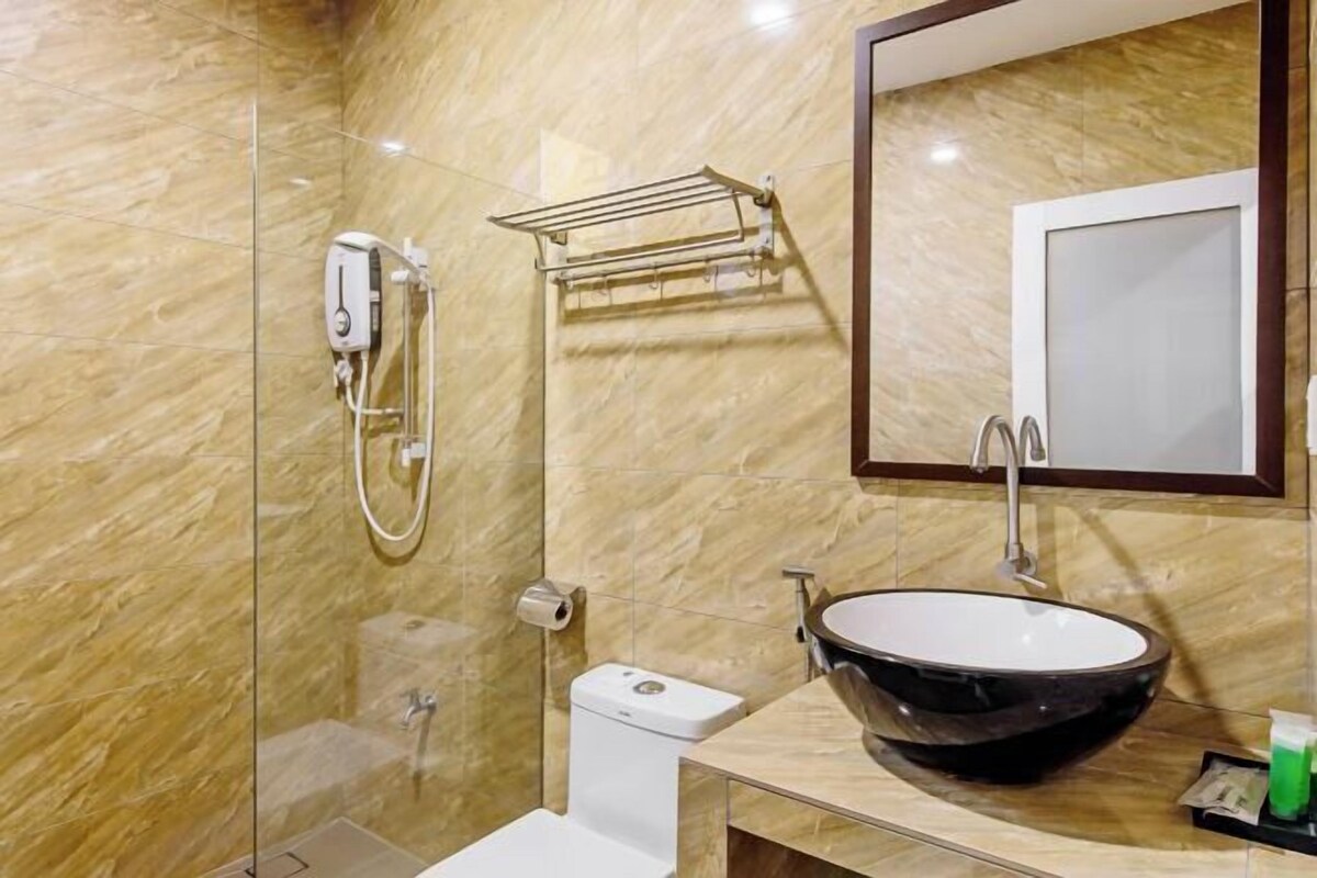 A bathroom with a glass-enclosed shower, a toilet, a sink with a large basin, and a towel rack.