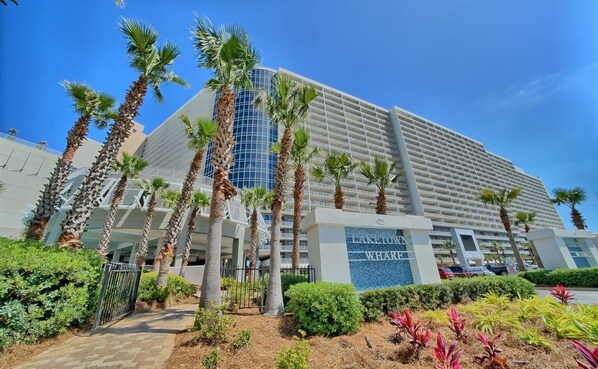 A high-rise hotel with a modern design, featuring a prominent sign for 'LAKE TOWN WHARF'. - Spacious East PCB Condo w/ Lake Views, Pools & Easy Beach Access (Panama City Beach)