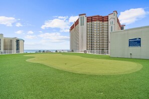 A golf course with a large building in the background.