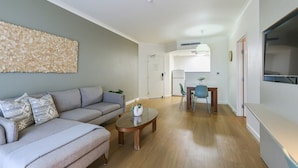 Un salon comprenant un canapé, une table basse et un coin repas avec des chaises.