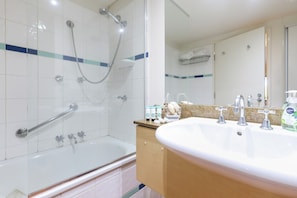 Un baño con ducha, lavabo y espejo.