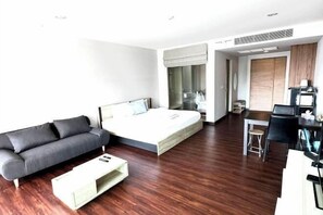 A modern hotel room with a bed, a sofa, a dining area, and a desk. - Ark Studio only 10 Minutes from kata/Karon Beach (Phuket)