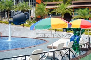 A pool area with a water feature, lounge chairs, and umbrellas. - Chomview Lanta Water Park Resort (Koh Lanta)
