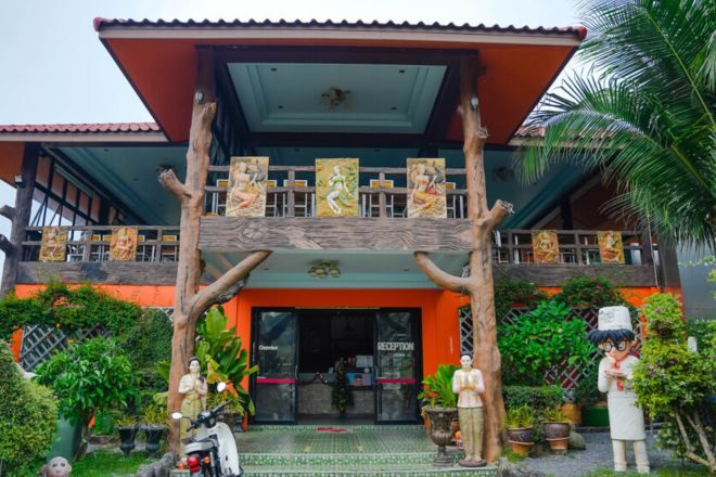 A building with a reception area, a covered entrance, and decorative statues.