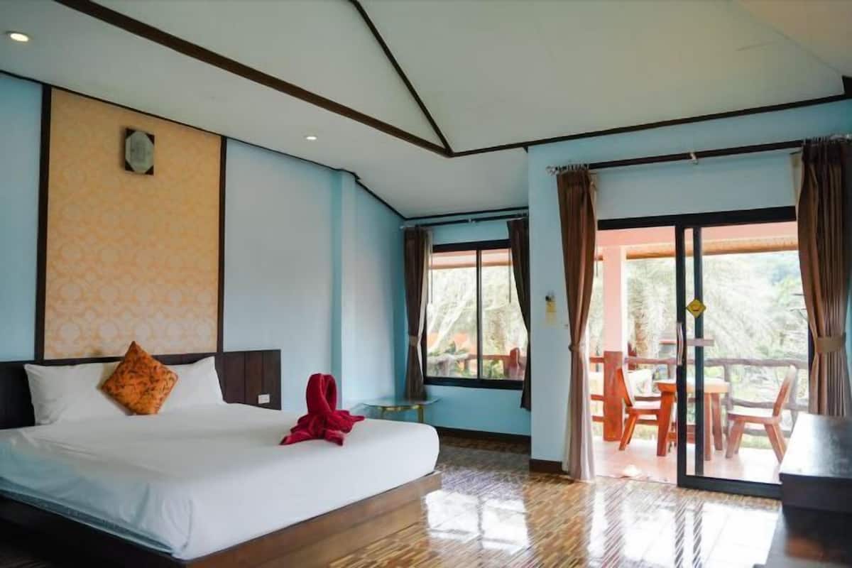 Ein Hotelzimmer mit Bett, einem kleinen Tisch und einem Balkon mit Stühlen.